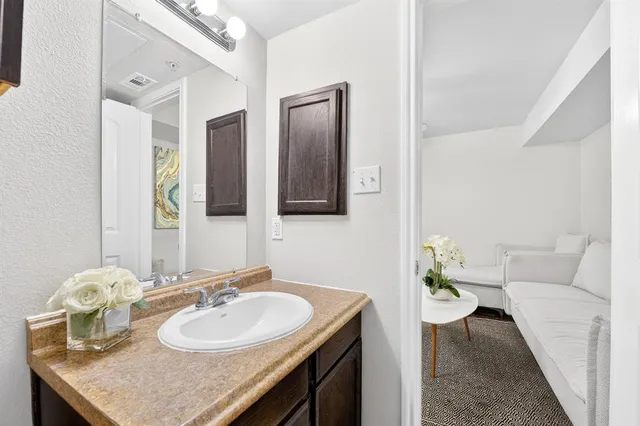 a en suite bathroom with a granite countertop sink and a mirror