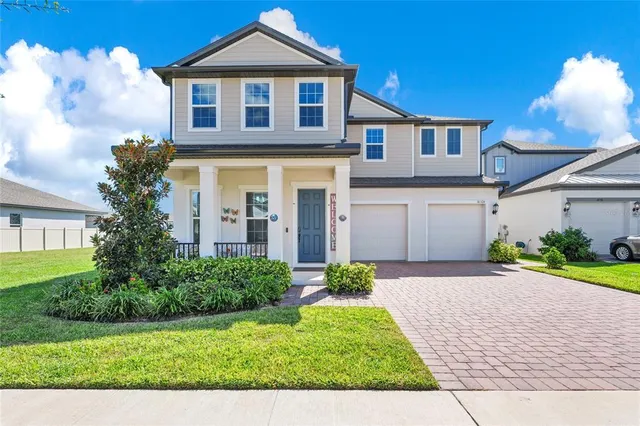 a front view of a house with a yard and potted plants