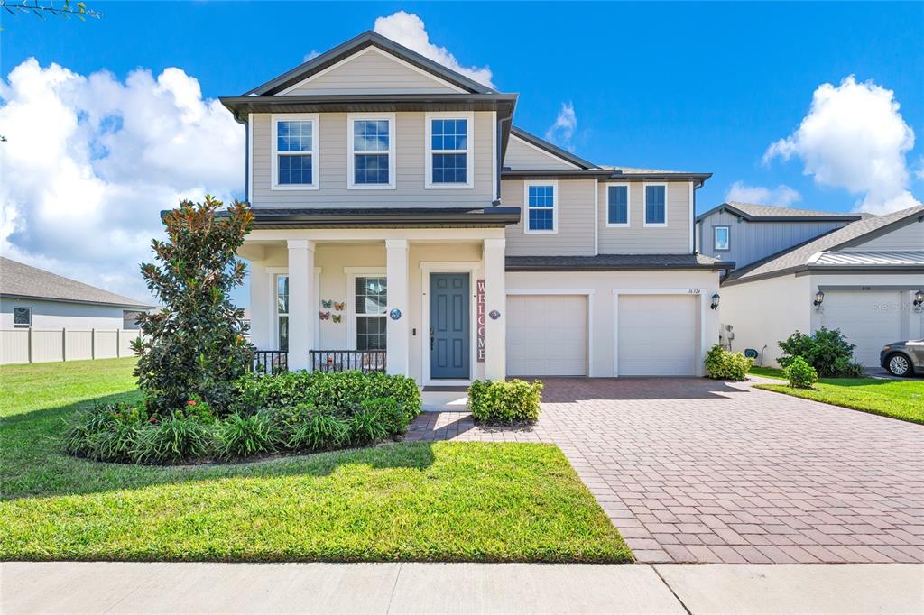a front view of a house with a yard and potted plants