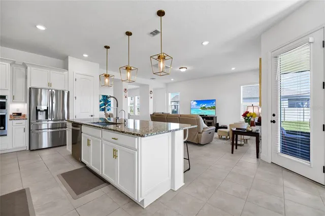 a kitchen with stainless steel appliances kitchen island granite countertop a sink and cabinets
