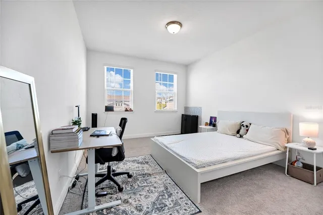 a bedroom with a bed a table and a flat screen tv