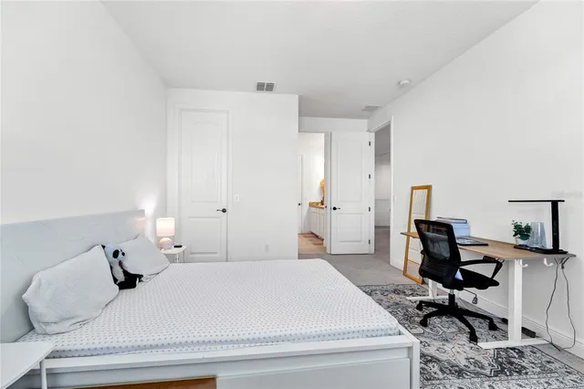 a bedroom with a bed and a chair in it