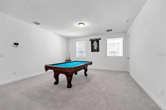 a room with pool table and windows