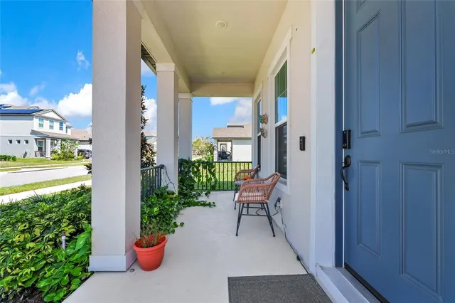 a view of a porch with chairs and plants