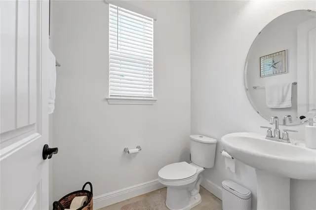 a bathroom with a sink toilet and a mirror