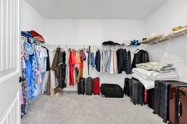 a view of walk in closet with clothes