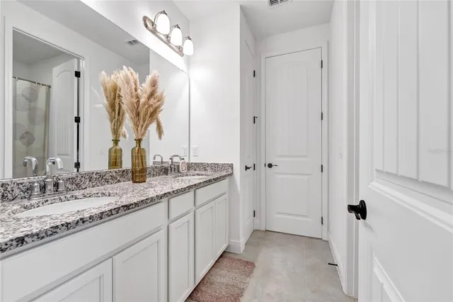 a bathroom with a granite countertop sink and a mirror