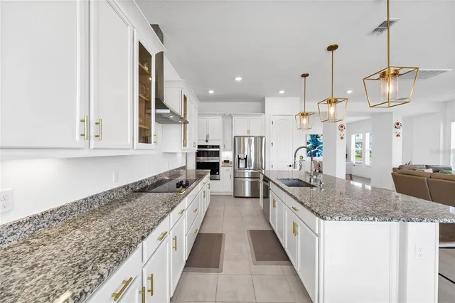a large kitchen with kitchen island granite countertop a sink and counter top space