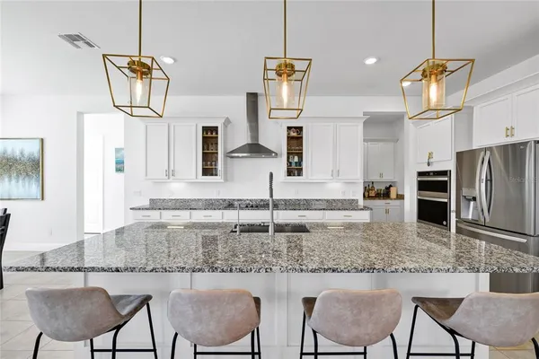 a kitchen with kitchen island granite countertop a stove a sink and a refrigerator