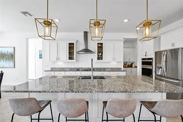 a kitchen with kitchen island granite countertop a stove a sink and a refrigerator