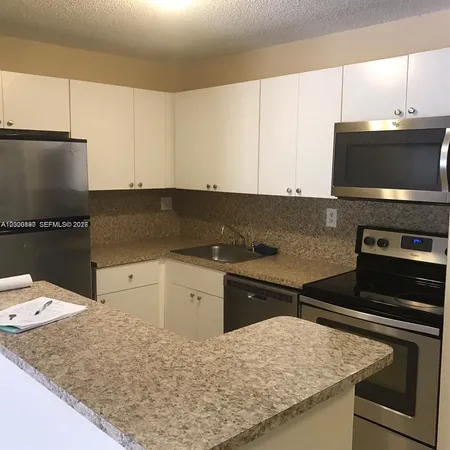 a kitchen with granite countertop a sink and a stove top oven