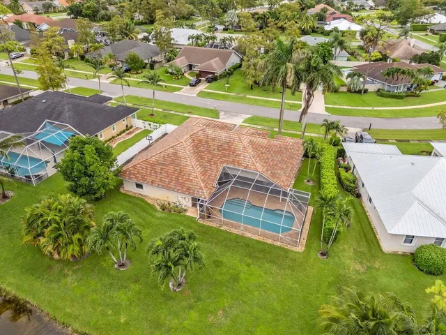 an aerial view of a house with a garden and lake view