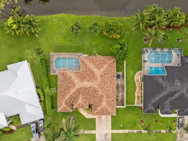 an aerial view of a house with a yard and lake view