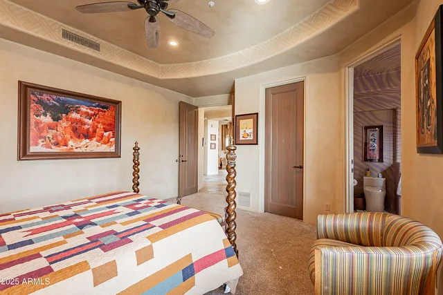 a bedroom with a bed a mirror and paintings on the wall