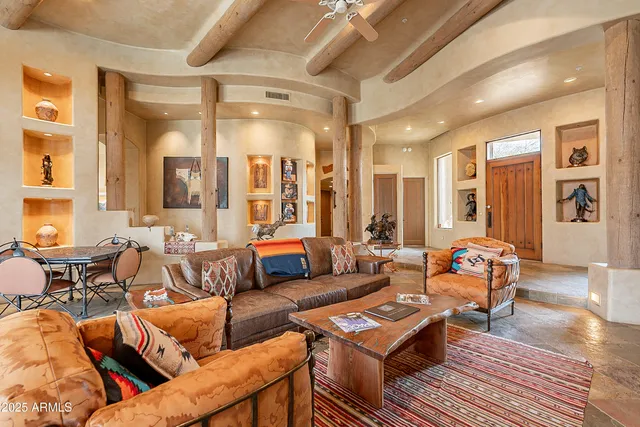 a living room with furniture fireplace and a large window