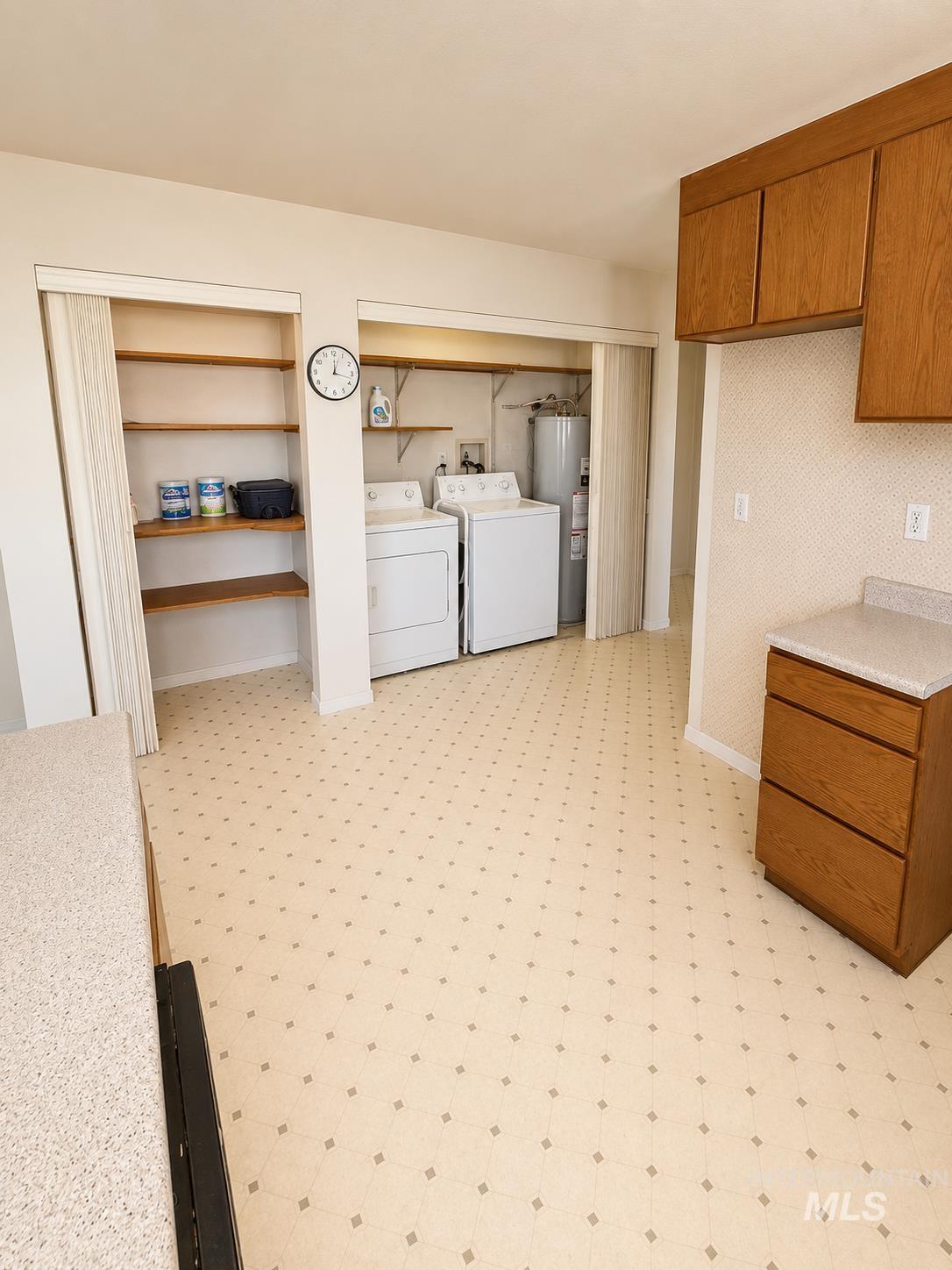 16434 Pride Lane Caldwell, ID 83607 - Photo 5 of 16 Laundry area featuring a side-by-side washer and dryer, adjacent built-in shelving, and a water heater