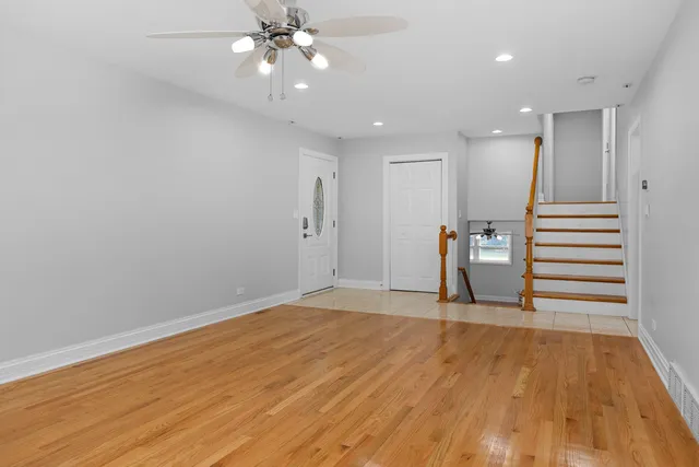 a view of a livingroom with wooden floor and staircase