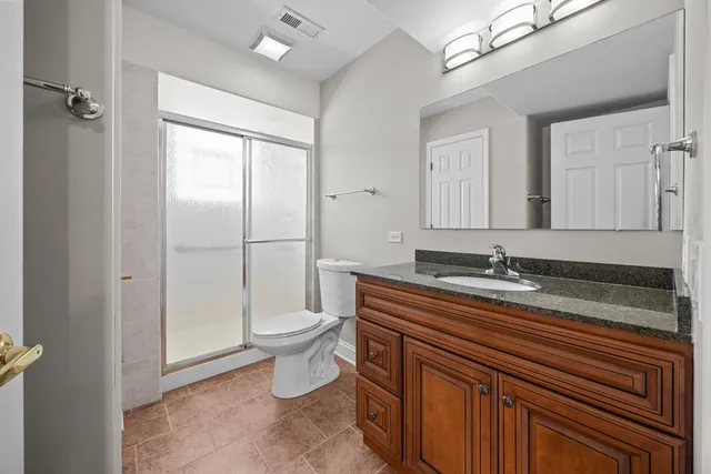 a bathroom with a granite countertop sink toilet and shower