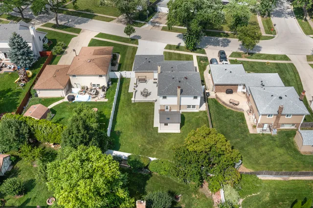 an aerial view of residential houses with outdoor space and trees