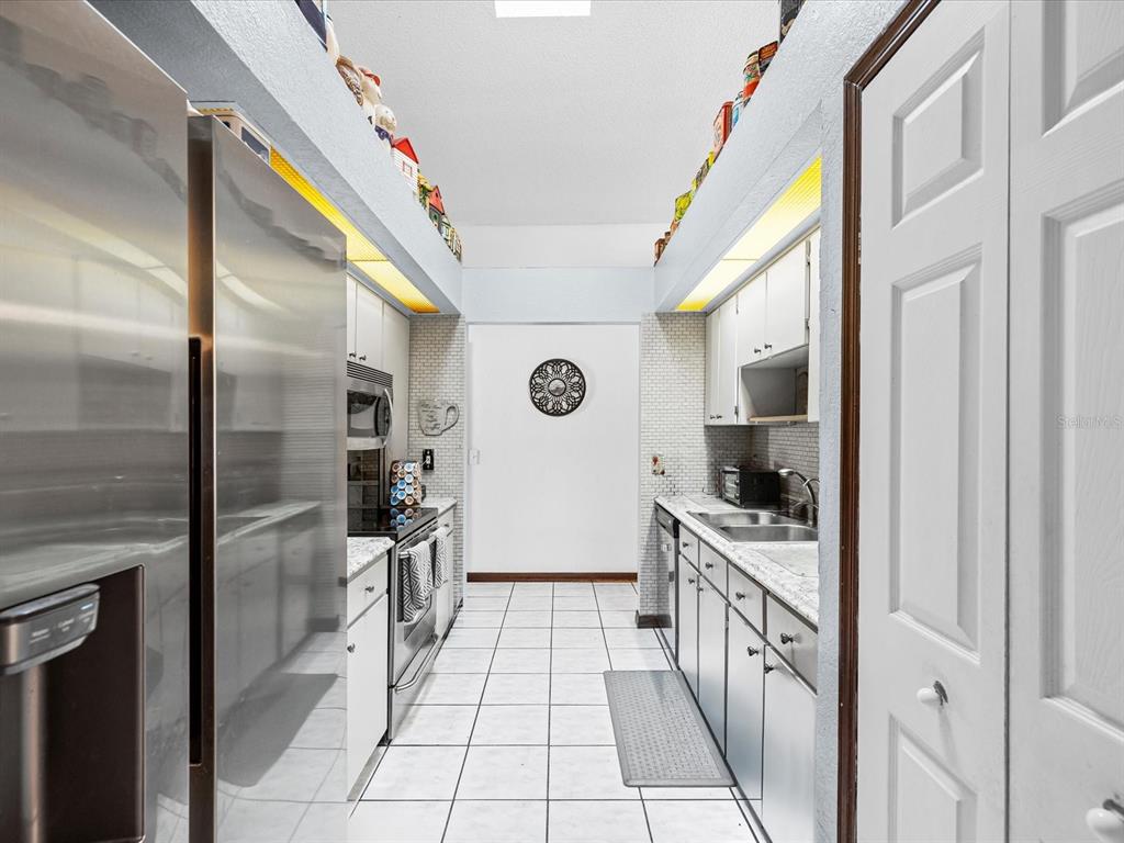 18824 Parade Road Hudson, FL 34667 - Photo 11 of 38 a hallway with cabinets and wooden floor