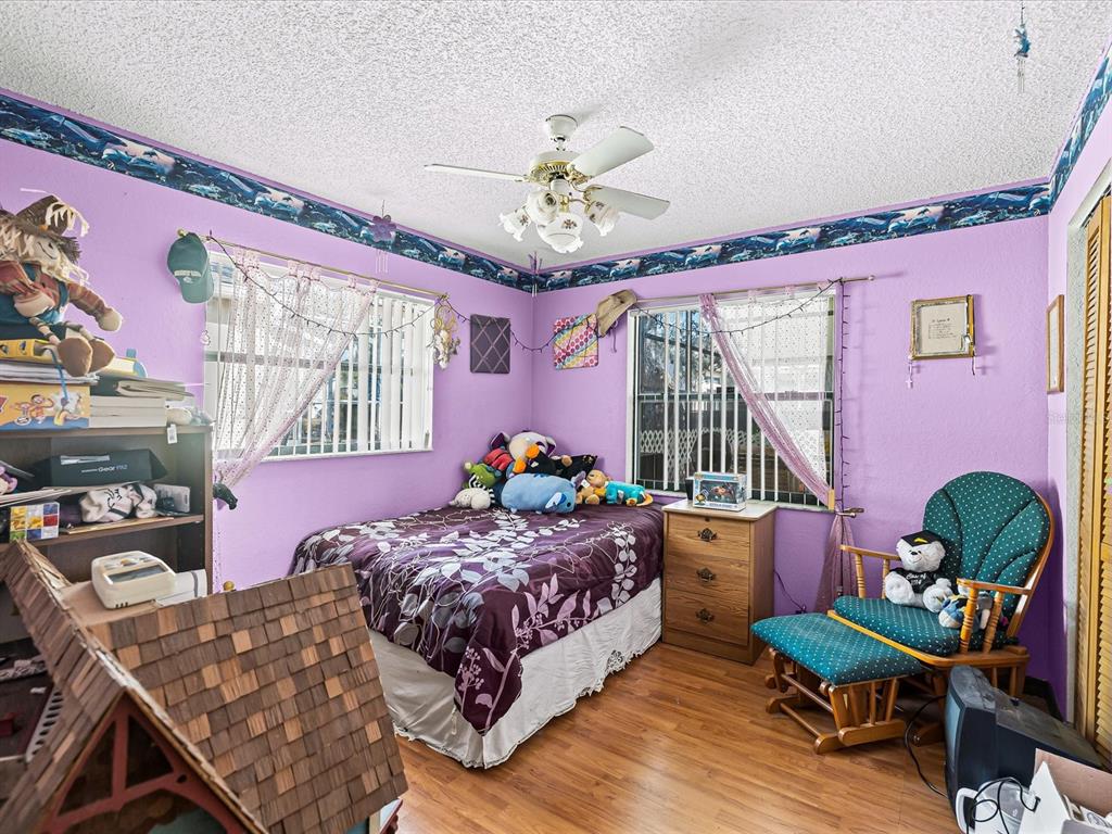 18824 Parade Road Hudson, FL 34667 - Photo 15 of 38 a bedroom with a bed and a chandelier