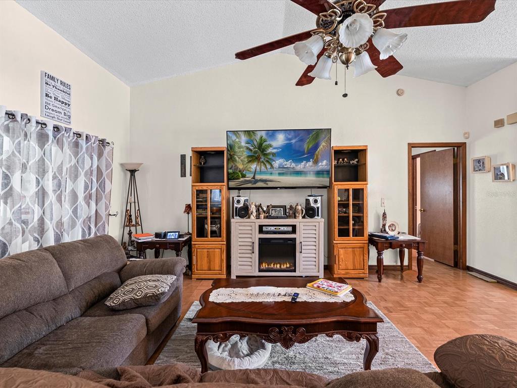 18824 Parade Road Hudson, FL 34667 - Photo 5 of 29 a living room with furniture a flat screen tv and a fireplace