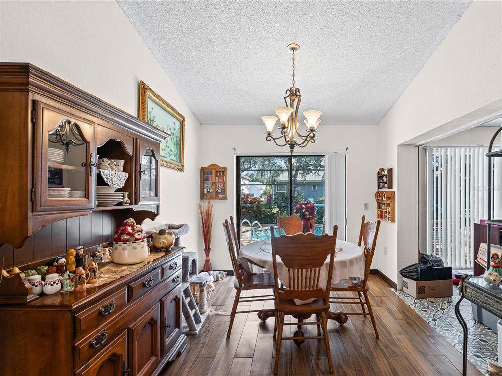 18824 Parade Road Hudson, FL 34667 - Photo 7 of 29 a dining room with furniture a chandelier and wooden floor