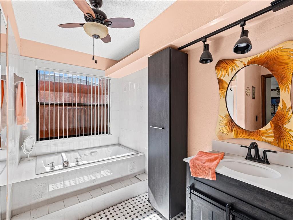 18824 Parade Road Hudson, FL 34667 - Photo 10 of 29 a bathroom with a sink a mirror and a shower