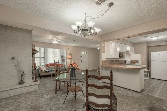 a view of a dining room with furniture a chandelier and wooden floor