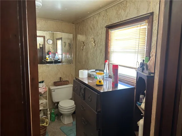 a view of bathroom with a toilet sink and mirror