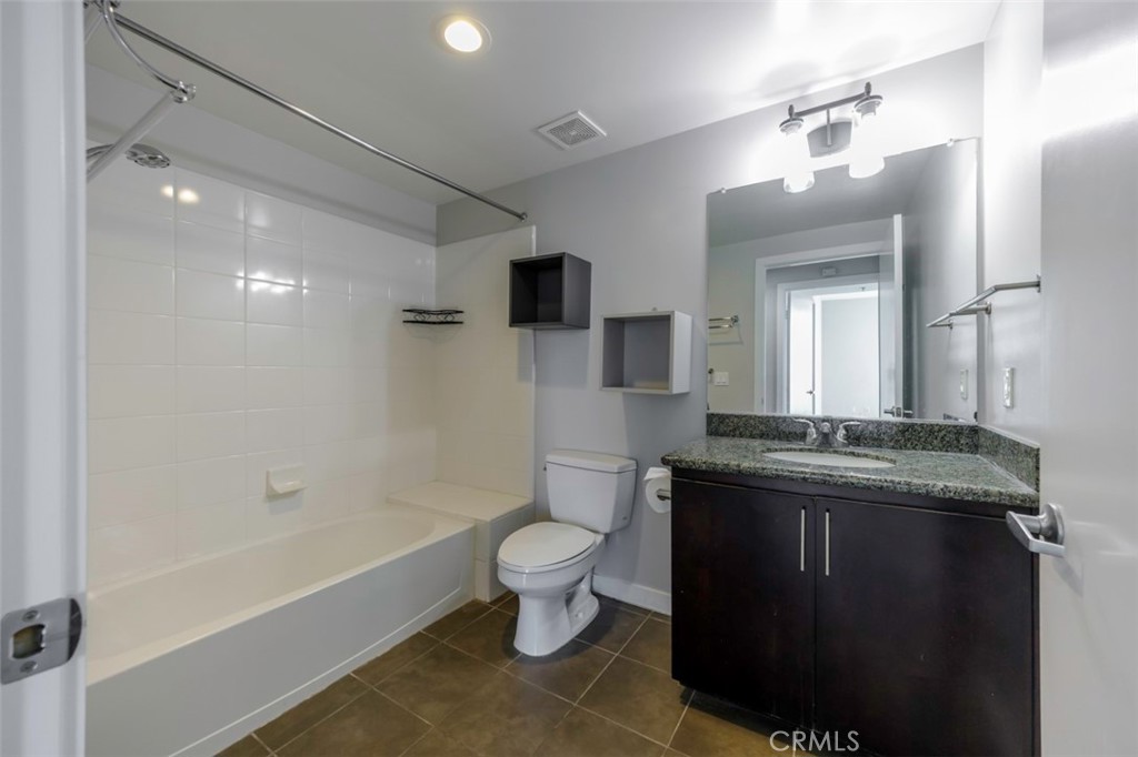 411 West Seaside Way, Unit 703 Long Beach, CA 90802 - Photo 16 of 52 a spacious bathroom with a granite countertop sink a toilet a mirror and bathtub