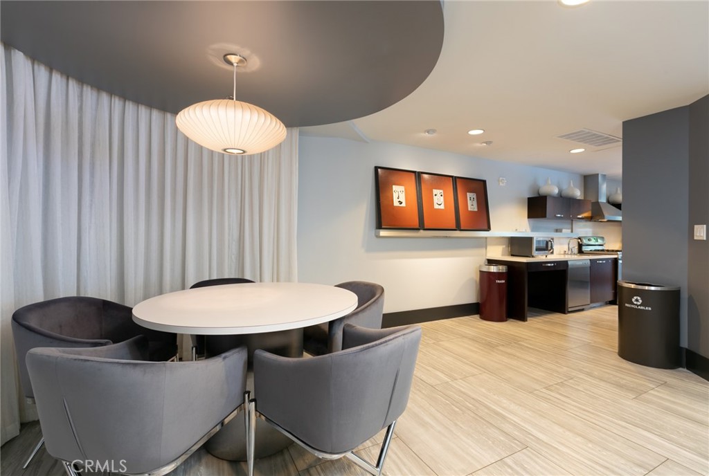 411 West Seaside Way, Unit 703 Long Beach, CA 90802 - Photo 41 of 52 a kitchen with stainless steel appliances a table and chairs in it