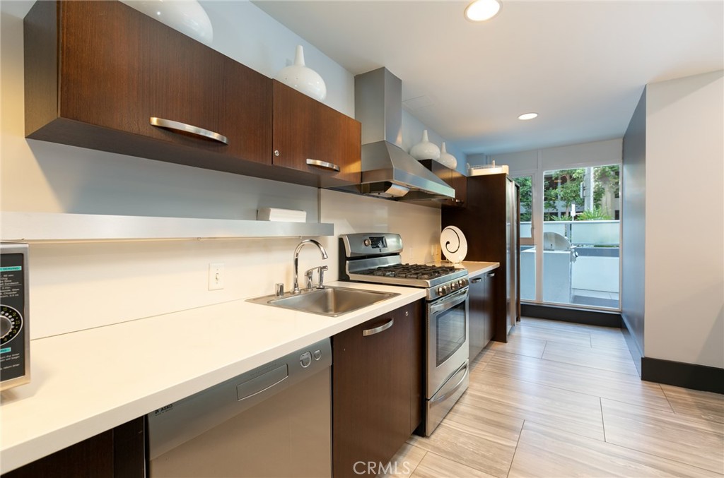 411 West Seaside Way, Unit 703 Long Beach, CA 90802 - Photo 42 of 52 a kitchen with stainless steel appliances granite countertop a sink a stove and a refrigerator
