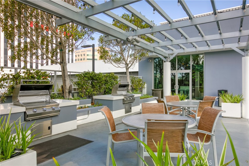 411 West Seaside Way, Unit 703 Long Beach, CA 90802 - Photo 49 of 52 a view of a patio with table and chairs and potted plants