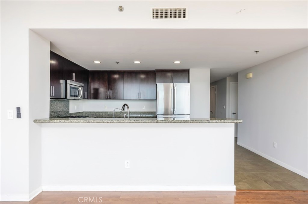 411 West Seaside Way, Unit 703 Long Beach, CA 90802 - Photo 6 of 52 a view of a kitchen with kitchen island a sink wooden floor and floors