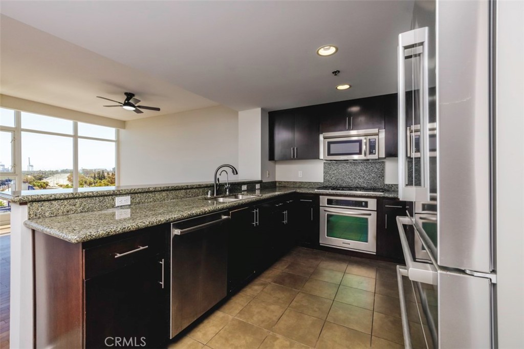 411 West Seaside Way, Unit 703 Long Beach, CA 90802 - Photo 8 of 52 a kitchen with stainless steel appliances granite countertop a sink stove and refrigerator