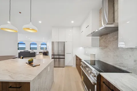 a kitchen with a sink a counter top space stainless steel appliances and cabinets