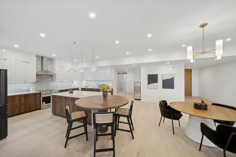 a kitchen with a dining table chairs and wooden floor