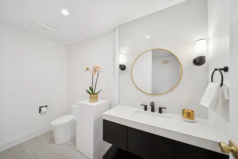 a bathroom with a sink a toilet and a mirror