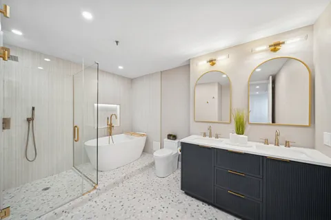 a spacious bathroom with a double vanity sink mirror and shower