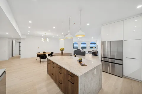 a kitchen with refrigerator and chairs