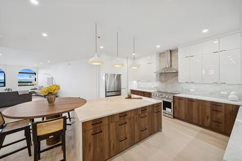 a kitchen with a table chairs sink and cabinets