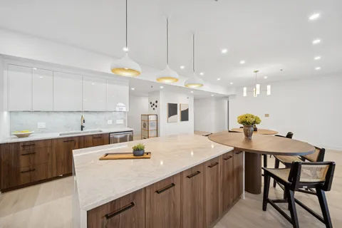 a kitchen with a dining table chairs sink and cabinets