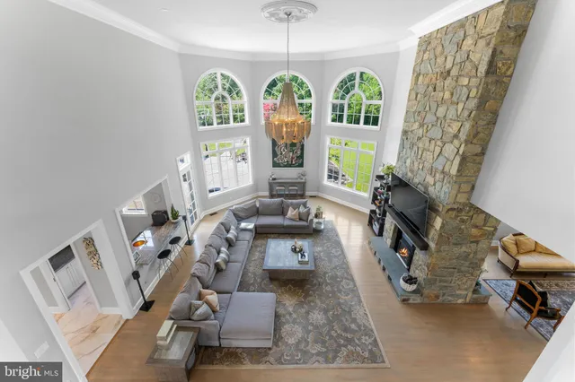 a spacious bedroom with a large bed a chandelier and next to a window
