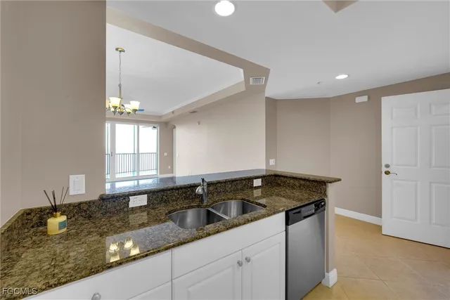 an empty room with windows and chandelier