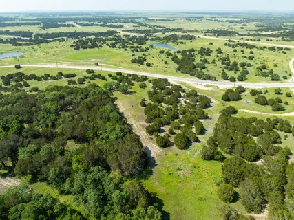 a view of a grassy field with trees in the background