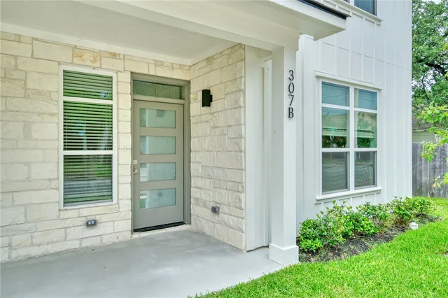 front view of a house with a large window and fire pit