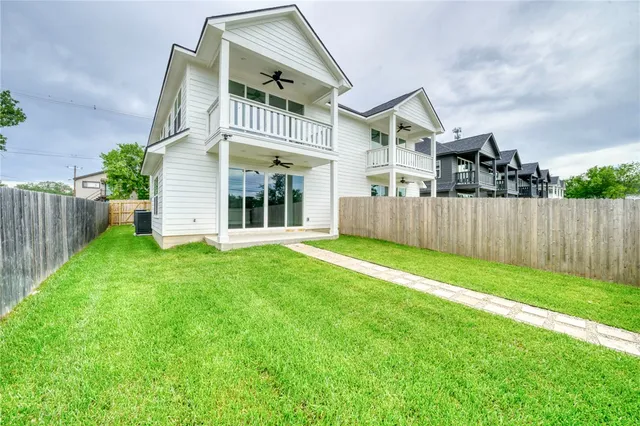 a view of a house with a yard and wooden fence