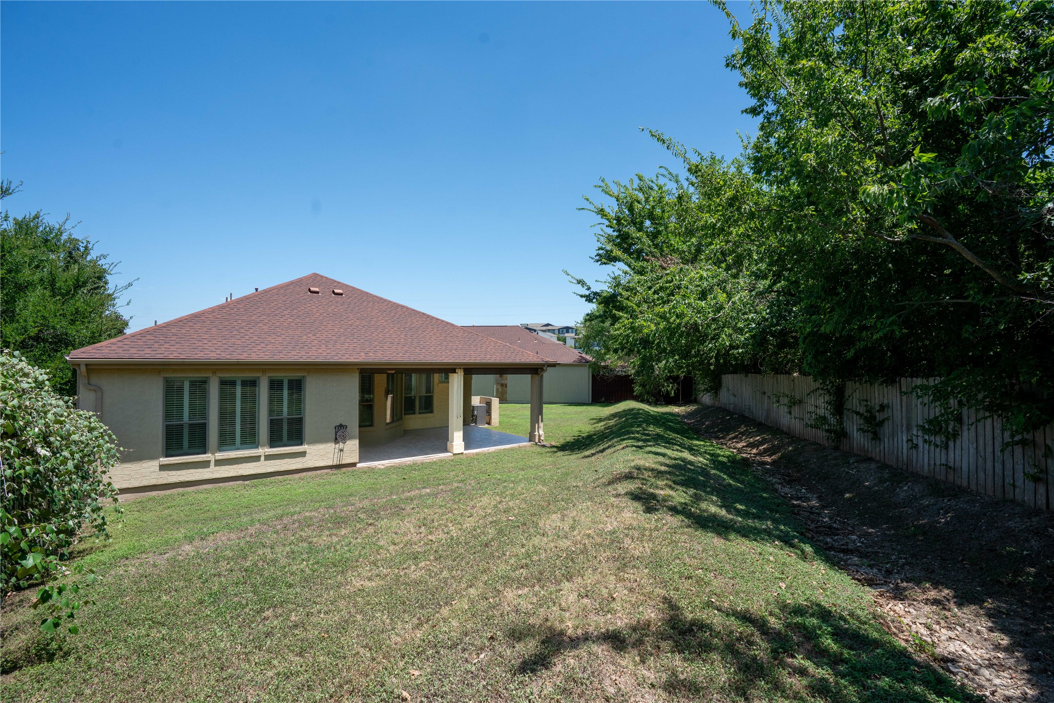 210 Rivulet Lane Austin, TX 78738 - Photo 27 of 28 A spacious backyard provides ample green space and a covered patio perfect for outdoor enjoyment.