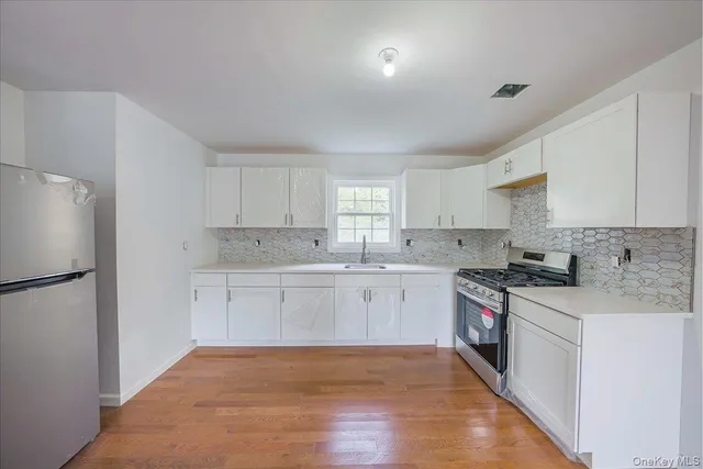 a kitchen with granite countertop white cabinets and white appliances